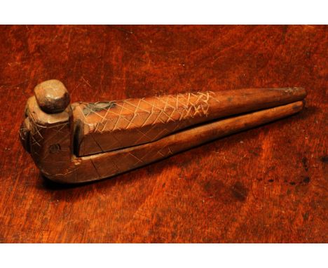 Nutcrackers - an 18th century fruitwood cross-over lever-action nut cracker, sgrafitto incised with hatched motifs, 18.5cm lo