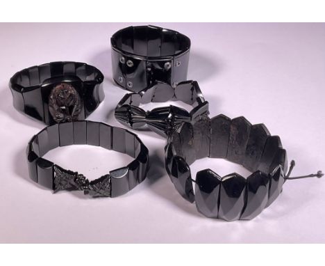 A Victorian Whitby Jet bangle bracelet; four other similar 