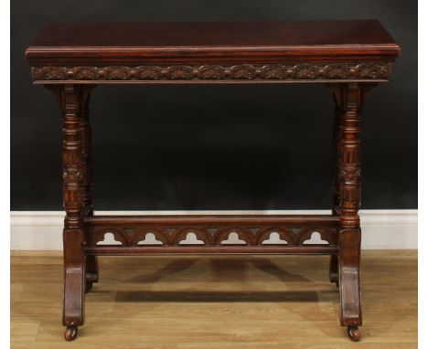 A Victorian Neo-Gothic oak card table, hinged top enclosing a baize lined playing surface above a deep frieze carved with lun