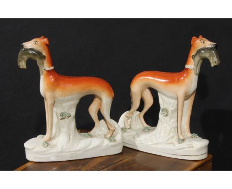 A pair of 19th century Staffordshire hunting dogs, each retrieving hare, 28cm high 