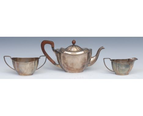 A George V silver oval three piece tea service, comprising teapot, milk jug and sugar basin, hardwood fittings, the teapot 29