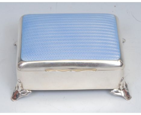 A George V silver and guilloche enamel rounded rectangular dressing table jewellery box, hinged cover, outswept leafy bracket