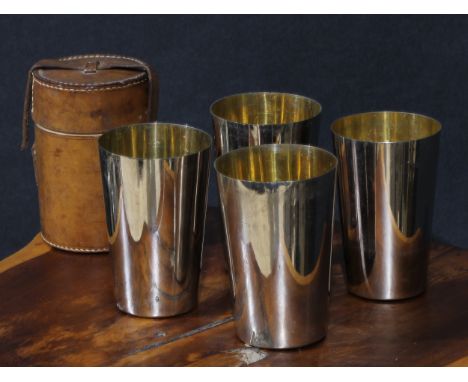 An Edwardian suite of four E.P.N.S nesting travelling hunting beakers, gilt interiors, 11cm high, leather case, c.1910 