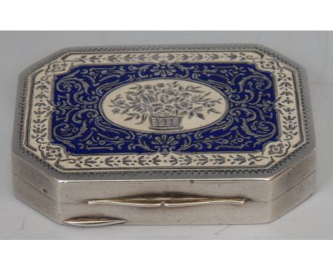 A Continental silver coloured metal and enamel canted rectangular rouge box, hinged cover decorated with a basket of flowers,