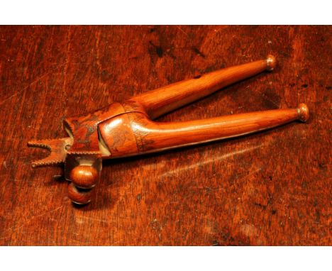 Nutcrackers - an 18th century yew wood crossover lever-action nut cracker, scrimshaw engraved with birds beside a flowering s
