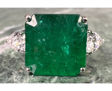 An Emerald and diamond ring, central square emerald cut emerald, approx 6.05ct mounted between pear drop cut diamond shoulder