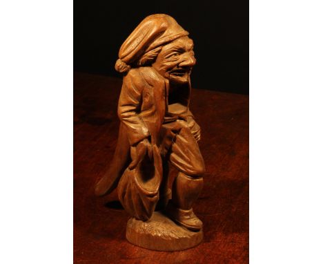 Nutcrackers - a Black Forest novelty table top lever-action nut cracker, carved as a poacher holding a sack, 21cm high, c.190