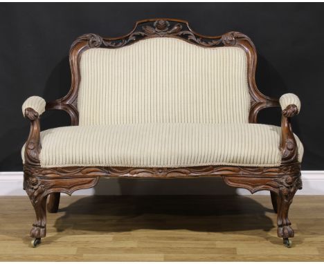 A 19th century mahogany sofa, pierced and carved with flowers and scrolling leaves, stuffed-over upholstery, lion paw feet, b