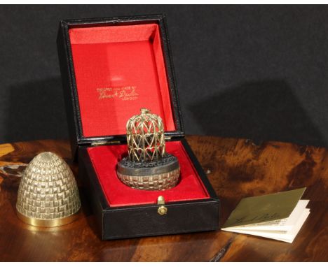 Stuart Devlin (1931 - 2018) - an Elizabeth II silver-gilt surprise egg, enclosing a parrot in a cage, no.139/300, London 1981