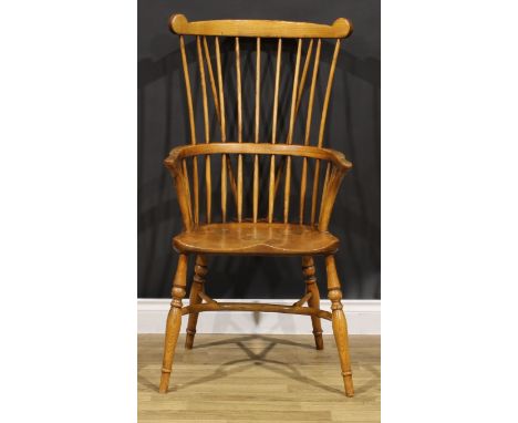 An ash and elm comb-back Windsor elbow chair, saddle seat, crinoline stretcher, 108cm high, 56cm wide, the seat 39.5cm wide a