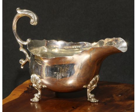 A George IV silver sauce boat, of substantial gauge, acanthus-capped flying scroll handle, hoof feet with shells to knees, 20