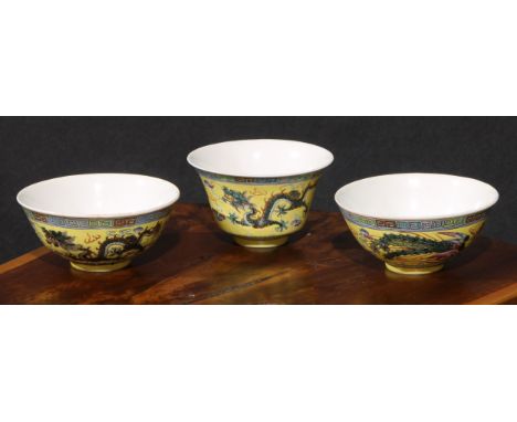 A garniture of Chinese circular bowls, each painted in polychrome enamels with dragons on a yellow ground, the pair 11.5cm di