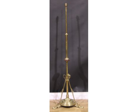 An Art Nouveau brass telescopic floor lamp, the pillar with turned disc, circular base with three whiplash buttresses, raisin