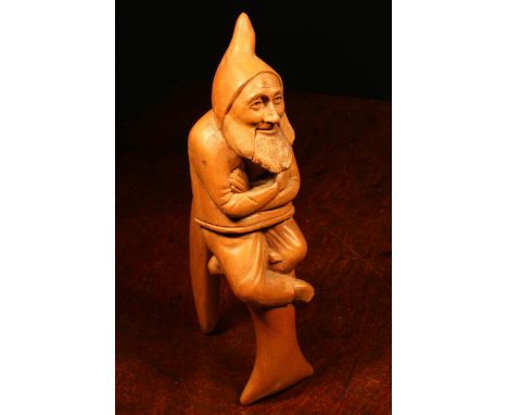 Nutcrackers - a Black Forest novelty lever-action nut cracker, carved as a gnome, full length, seated with arms folded, 24cm 