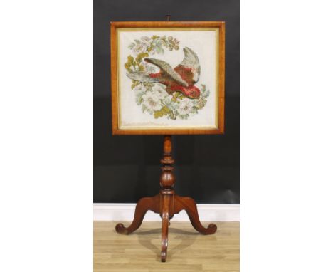 A large early Victorian mahogany tripod polescreen, the rectangular banner worked in raised and cushioned woolwork with a par