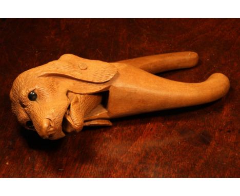 Nutcrackers - a Black Forest novelty lever-action nut cracker, carved as the head of a dog, glass eyes, 18cm long, c.1900 