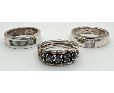 3 silver stone set band style dress rings to include a channel set, baguette cut blue topaz ring. Silver marks to inside of b