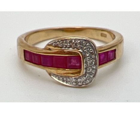 A 9ct gold ruby and diamond set buckle style dress ring. Band channel set with 5 square cut rubies. Buckle detail set with 4 