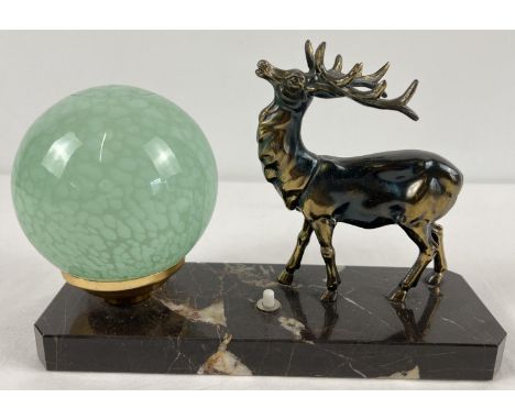 An Art Deco design table lamp with spelter figure of a stag and spherical green glass shade. On a black marble base with pres