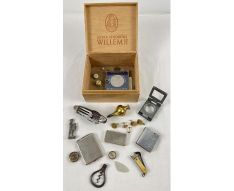 A vintage cigar box of assorted misc items. To include: cigar cutter; lead figure; folding book shaped lighter; buttons; Stag