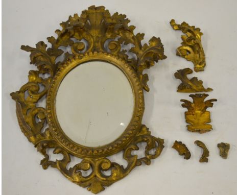 A 19th century giltwood Florentine wall mirror with carved and pierced foliate frame and oval bevelled plate, 46 cm high (f/r