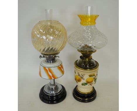 An Edwardian oil lamp with moulded glass shade, the stoneware base painted with fruit, 58 cm to/w a 1920s oil lamp with flora