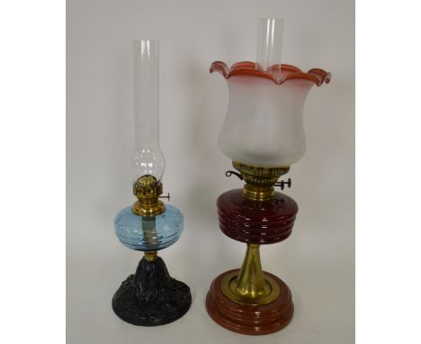 An Edwardian oil lamp with etched glass shade of ruby glass reservoir, on tapering brass pillar and ceramic foot, 57 cm high 