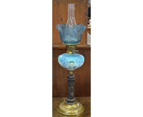 A Victorian oil lamp with blue glass shade and floral-painted blue glass font, on foliate moulded ceramic pillar and brass fo