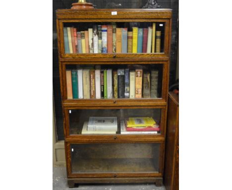 An oak four section Globe Wernicke bookcase raised on a black foot base to/w a spare top and base