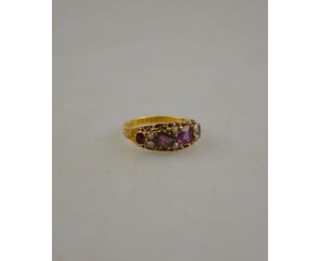 A Victorian amethyst and seed pearl ring having two heart shaped amethysts to centre, and two oval amethysts and six half pea