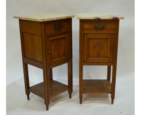 A pair of antique French marble topped oak bedside cabinets with carved frieze drawers over panelled cupboards and a pot shel