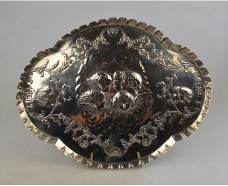 An Edwardian silver quatrefoil trinket tray embossed with winged cherub heads within foliate border, James Deakin & Sons, Che