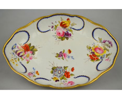An early 19th century Derby oval dish painted with sprays of flowers within open blue and gilt vignettes, painted red factory