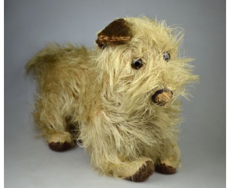 A vintage Chiltern Toys Rough-coated terrier, with plush ears and pads, glass eyes (velvet nose a/f), 32 cm high x 50 cm long