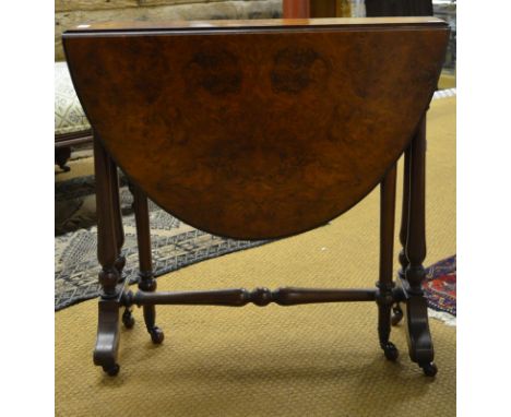 Victorian burr walnut Sutherland table, the hinged oval top raised over a turned gateleg frame, on ceramic castors