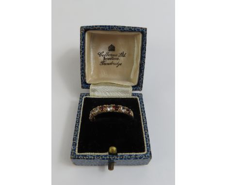 A 9ct gold garnet and white stone half eternity ring, finger size Q 1/2, 2.52g gross, in a 'Colborne Ltd Jewellers Trowbridge