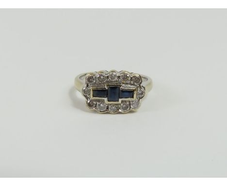 An 18ct gold sapphire and diamond cluster ring, the central step cut sapphire with a step cut sapphire set horizontally to ea