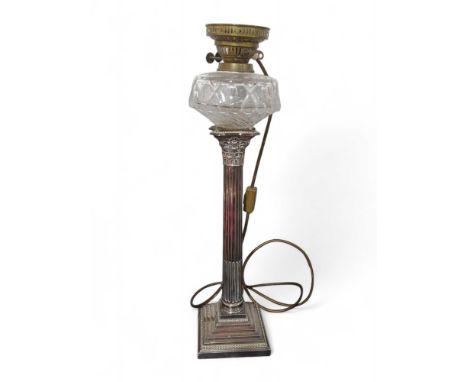 An Edwardian oil lamp, the moulded glass reservoir on tall silver plated Corinthian column on stepped square base, 64cms high