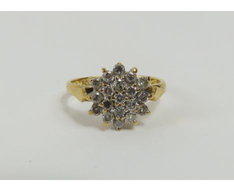 An 18ct gold diamond cluster ring, the round brilliant cut stones claw set, finger size J 1/2, 3g gross