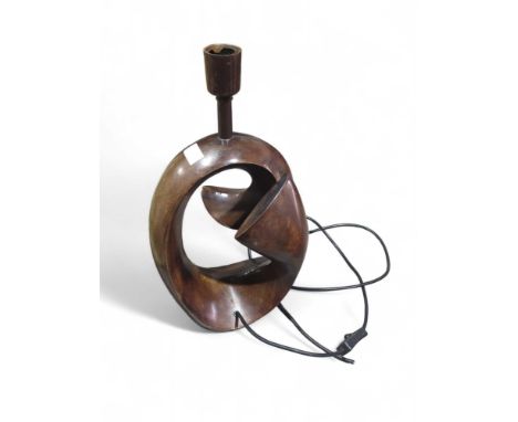 A contemporary artistic metal lamp, dark brown in complexion and of a minimalist and swirling composition. About 45cm tall