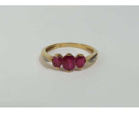 A ruby and diamond dress ring, the three oval rubies graduated and with two small diamonds set into the shoulders, finger siz