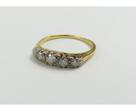 An early 20th century graduated five stone diamond ring, finger size N, tests as approximately 18ct gold, 2.64g gross, in an 
