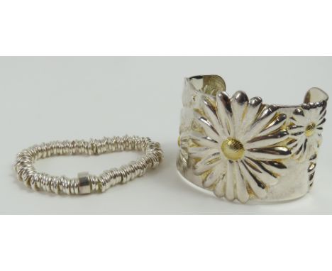 A silver bracelet comprised silver rings with a "central" larger ring marked "925". Unknown maker. Alongside a silver torque 