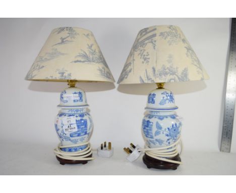 PAIR OF CERAMIC TABLE LAMPS AND SHADES WITH A BLUE AND WHITE CHINESE DESIGN