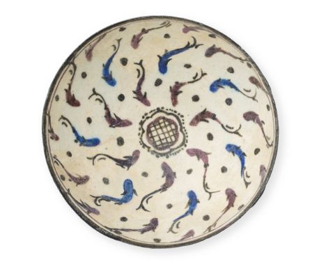 A Kashan underglaze-painted pottery bowl Persia, 12th-13th Centuryof deep rounded form on a long foot, decorated in cobalt-bl