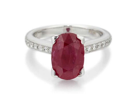 AN 18 CARAT WHITE GOLD RUBY AND DIAMOND RING an oval-cut ruby to diamond-set shoulders. Estimated total diamond weight 0.45ct