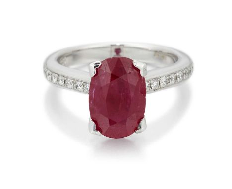 AN 18 CARAT WHITE GOLD RUBY AND DIAMOND RING an oval-cut ruby to diamond-set shoulders. Estimated total diamond weight 0.45ct