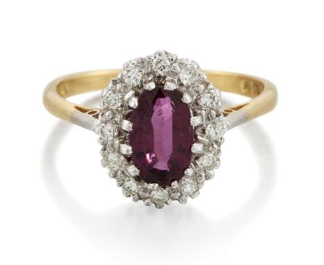 AN 18 CARAT GOLD RUBY AND DIAMOND CLUSTER RING an oval-cut ruby within a border of round brilliant-cut diamonds. Total diamon