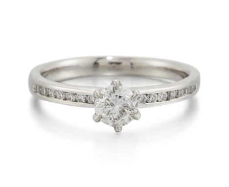 A PLATINUM SOLITAIRE DIAMOND RING a round brilliant-cut diamond in a claw setting to channel-set diamond shoulders. Principal