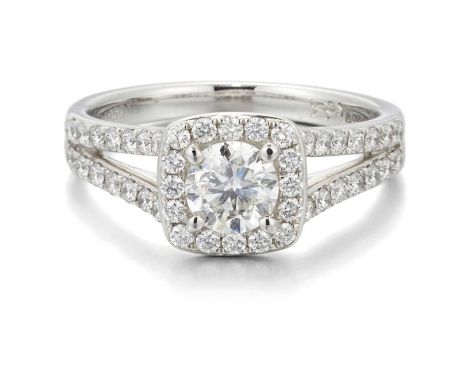 A PLATINUM DIAMOND CLUSTER RING a round brilliant-cut diamond within a diamond-set halo border and to forked diamond-set shou